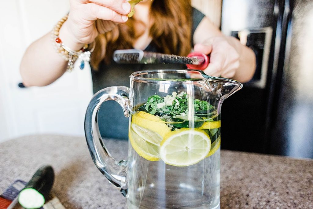 Andie using microplane to grate the ginger into the sassy water recipe.
