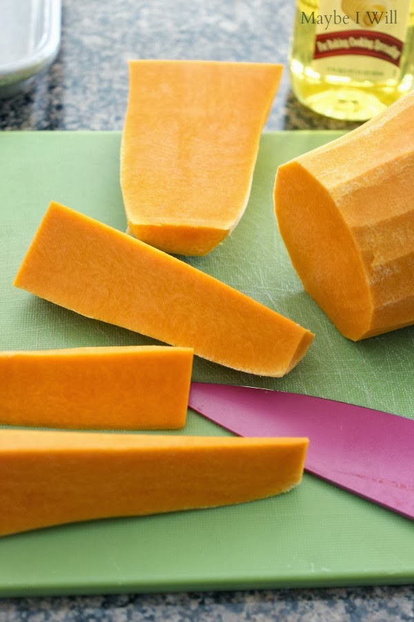 Savory Roasted Butter Squash with Butter Flavored Olive Oil... So savory and delightful!!! Bright orange butternut squash being chopped on green cutting board with a pink knife