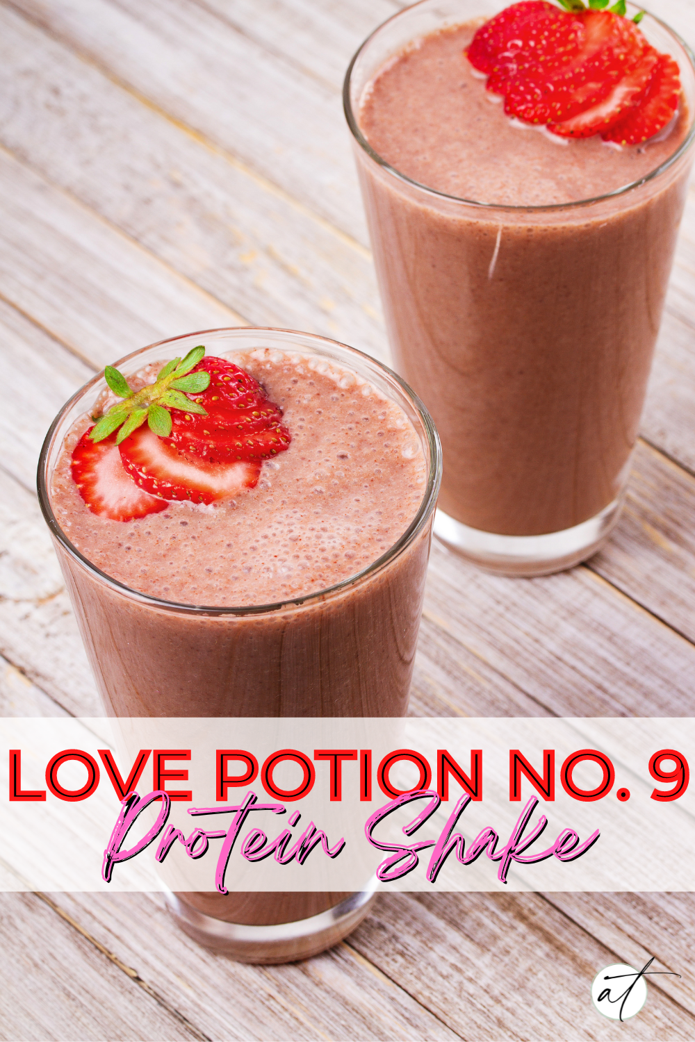 Image of two chocolate strawberry protein shake arranged beautifully on a wood table top. Fresh strawberries adorn the top. 