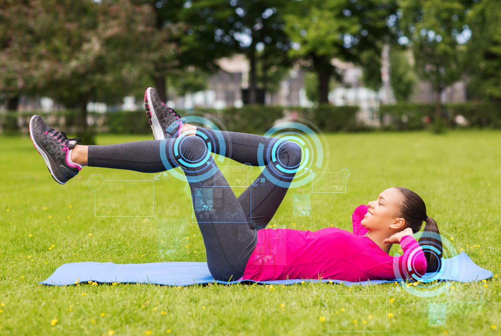 smiling woman doing exercises on mat outdoors