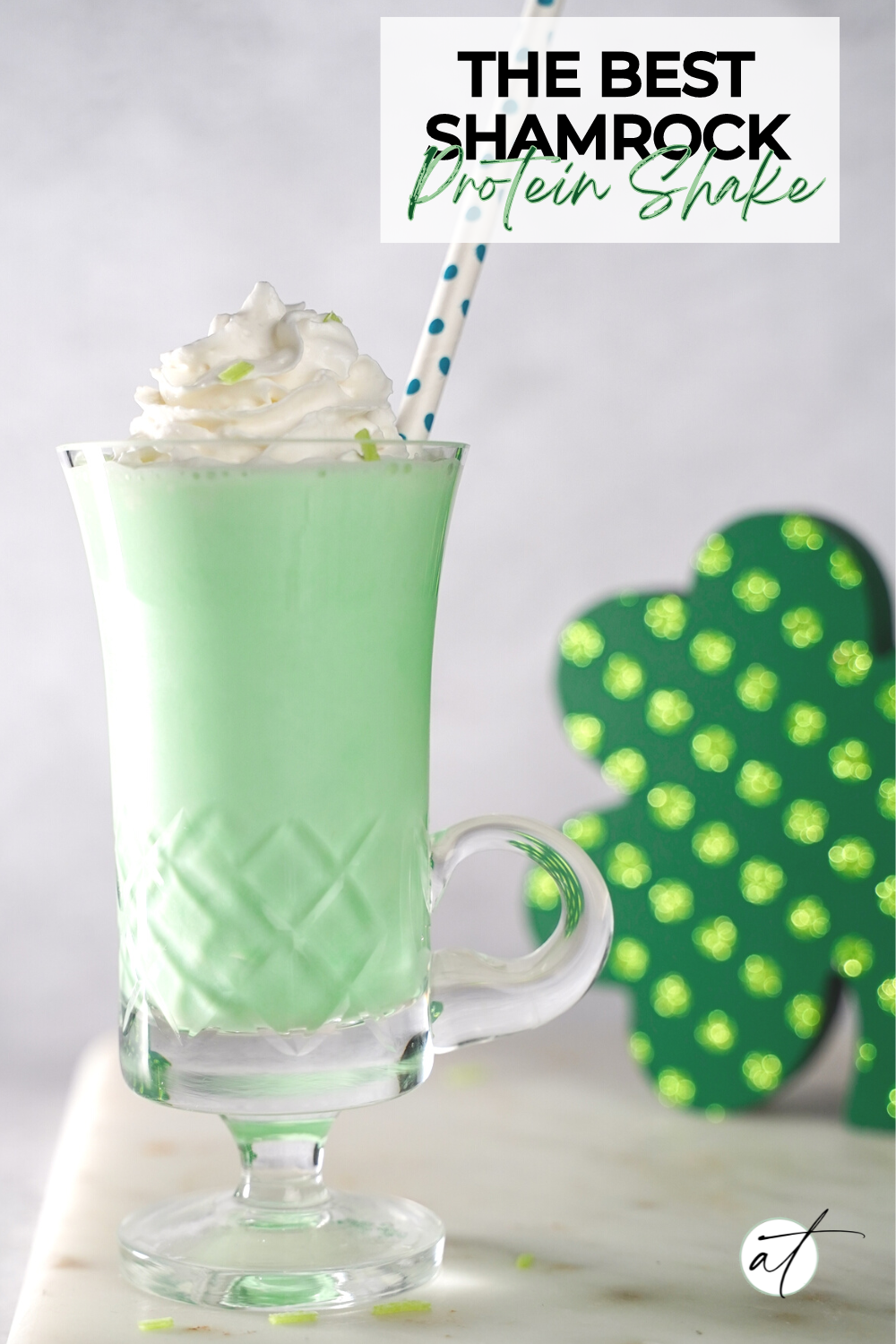 Photo of Shamrock protein shake beautifully styled with a green shamrock in the background.