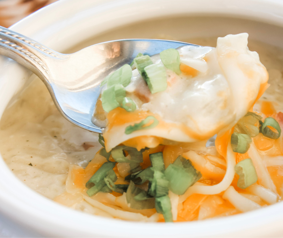 Close up of a spoonful of this hearty delicious hash brown potato soup. Close up showcases the rich and creamy texture of the soup. 