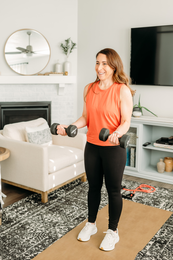 Andie holding ten pound weights while completing 7's a serious of 3 different targeted bicep movements for the back and bicep workout for women. 