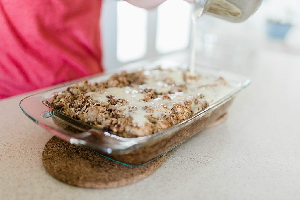 Andie is pouring the warm sauce over the warm baked bread pudding.
