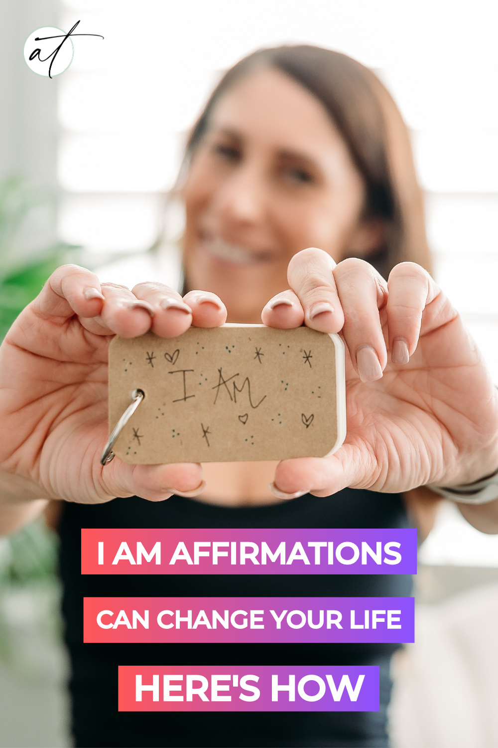 Photo of Andie holding I am affirmation booklet she uses to as a guide to her daily affirmations. 