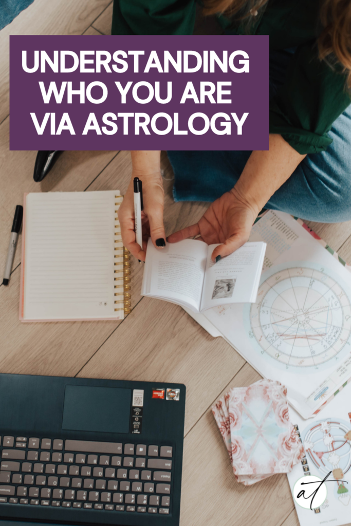 Image of Andie sitting on the ground with a laptop reading am Astrology natal birth chart. 