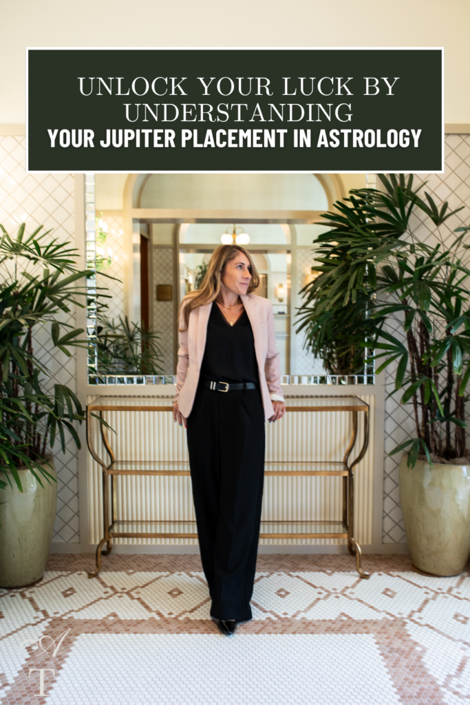 Andie standing in a fancy entryway, she is looking off into the distance contemplating her Jupiter placement in astrology 