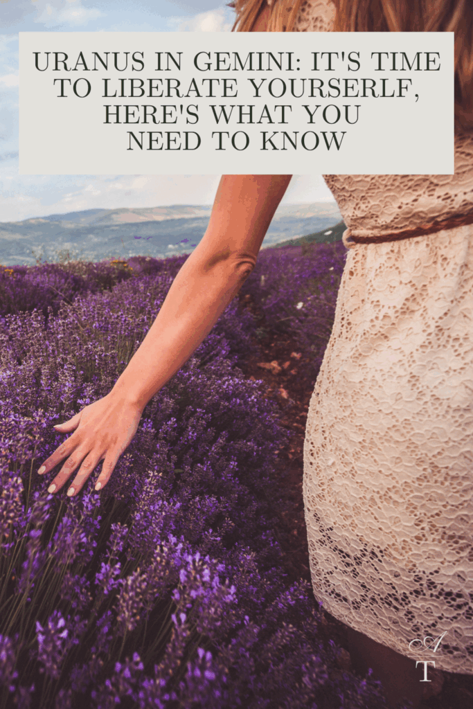 Image of a woman walking through a lavendar field she is wearing an ivory lace dr5ess and is touching the lavendar with her hands as they move with the breeze, the words "Uranus in Gemini: It's Time To Liberate Yourserlf, Here's What You
Need To Know" are written over the top of the image.