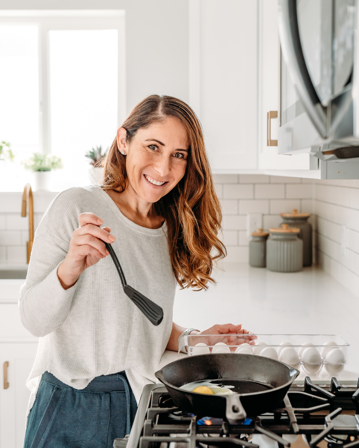photo of Abdie at home in the kitchen, cooking up some eggs. 